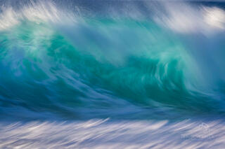Abstract wave photography image from Deron Verbeck Photography with swirls of white and blue as the wave crashes in.